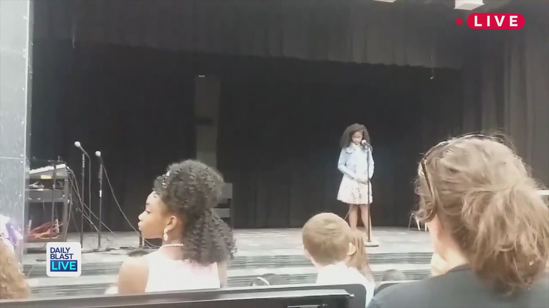 Shay Washington just wanted to help her daughter who was battling stage fright during a school performance, but she never expected the viral reactions to come! The video shows Washington walking onstage and holding her daughter after she paused during a p