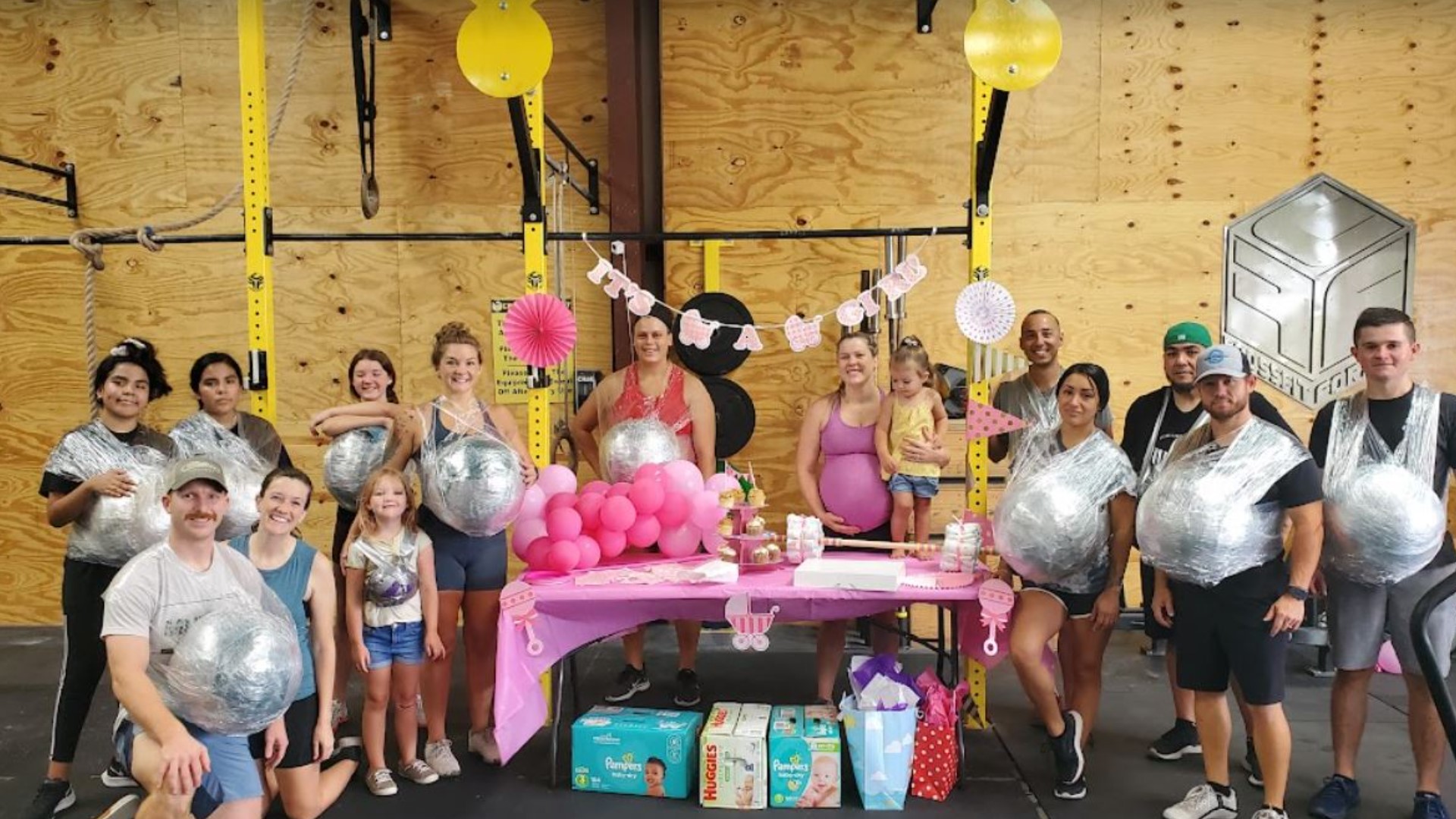 Athletes at CrossFit Forney fastened medicine balls to their stomachs to salute Mandi Sohail, an expecting mom who regularly works out despite her baby bump.