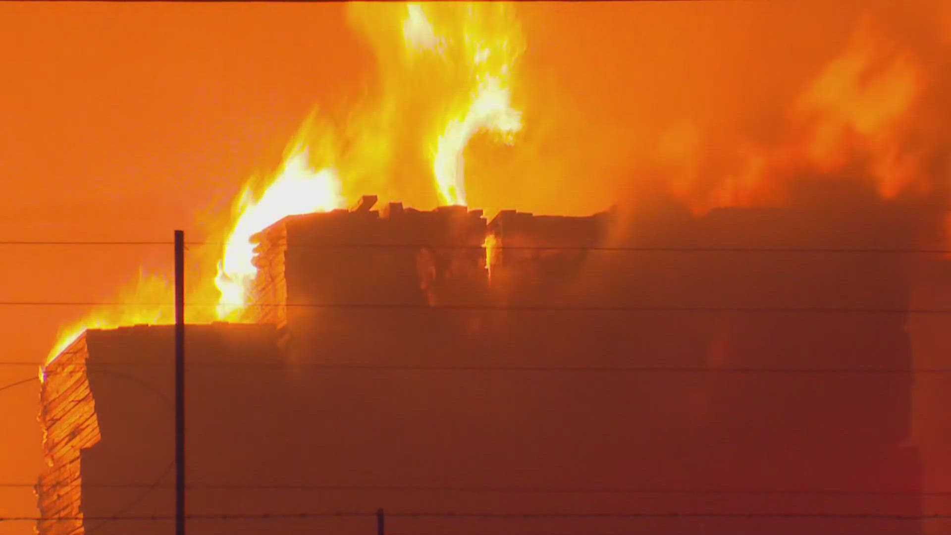 A large fire burning near Dallas Love Field knocked out power to over 1,400 people Tuesday morning.