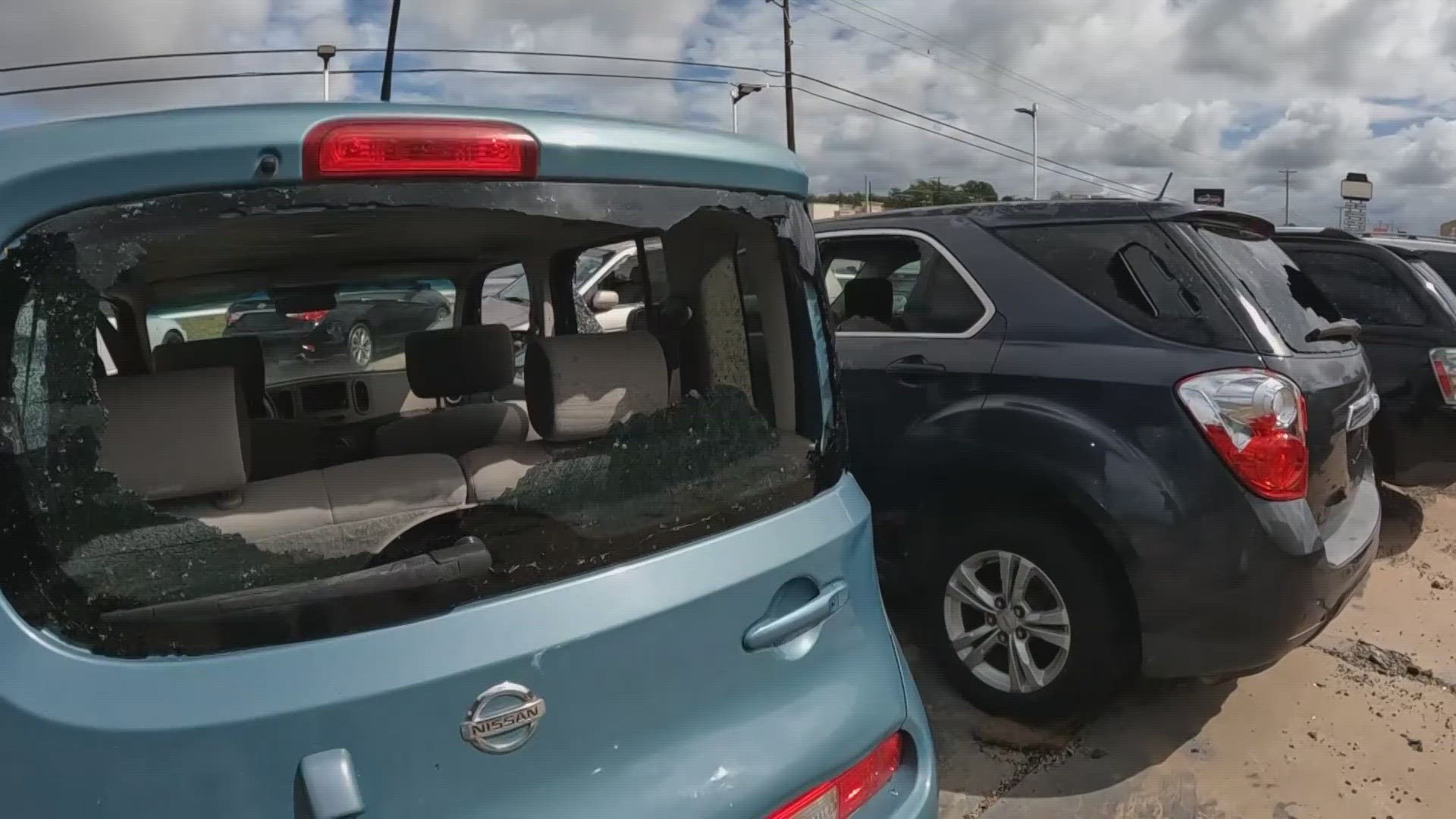 Special Touch II Auto Sales owner Edward Andrews estimates 30 to 35 cars need new windows after wind blew a nearby roof into his lot.