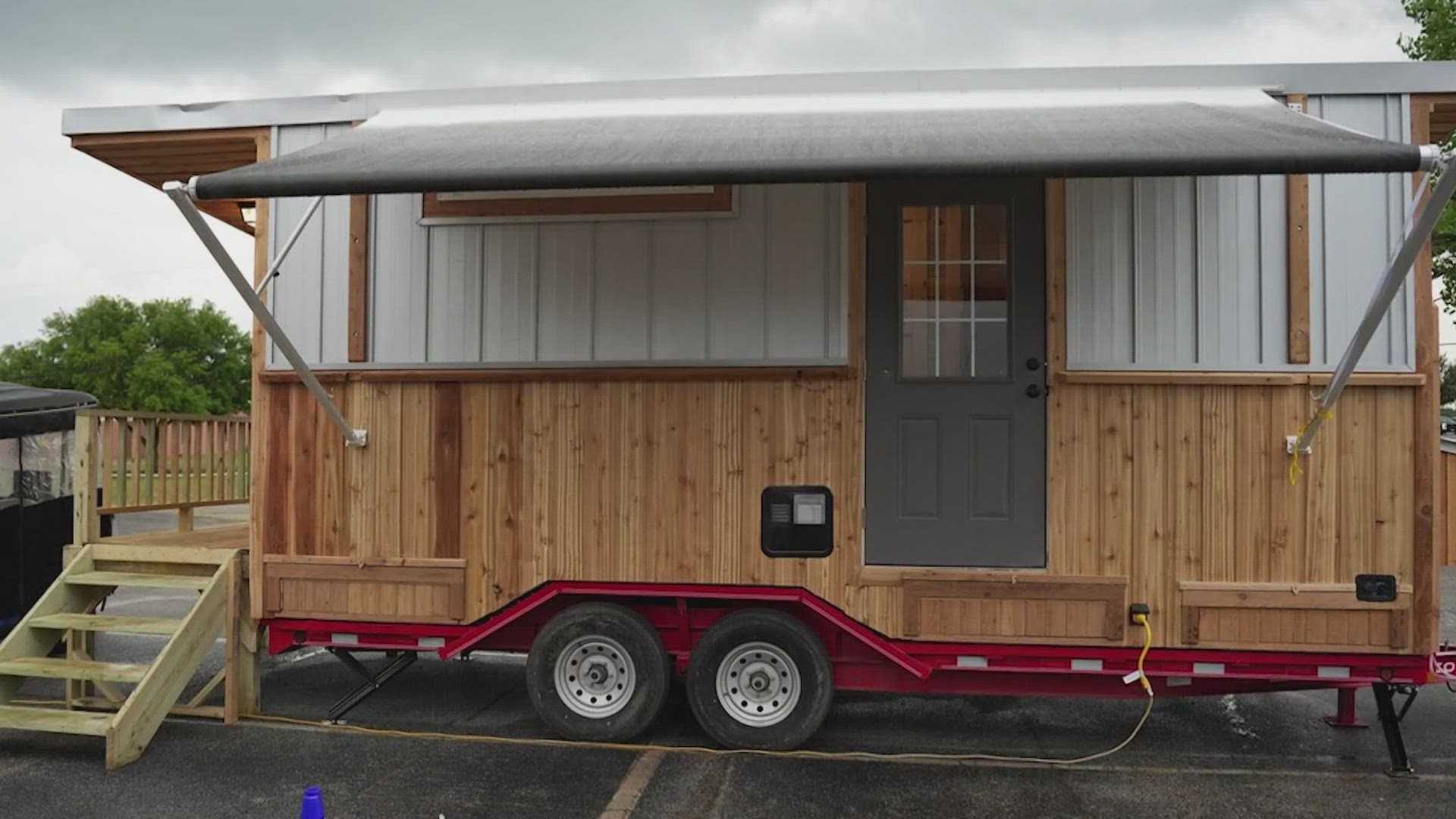 The tiny home features a full-size shower, residential toilet, a full-size Murphy bed, microwave, three burner cooktop, oven, refrigerator, A/C, and (a little) more!