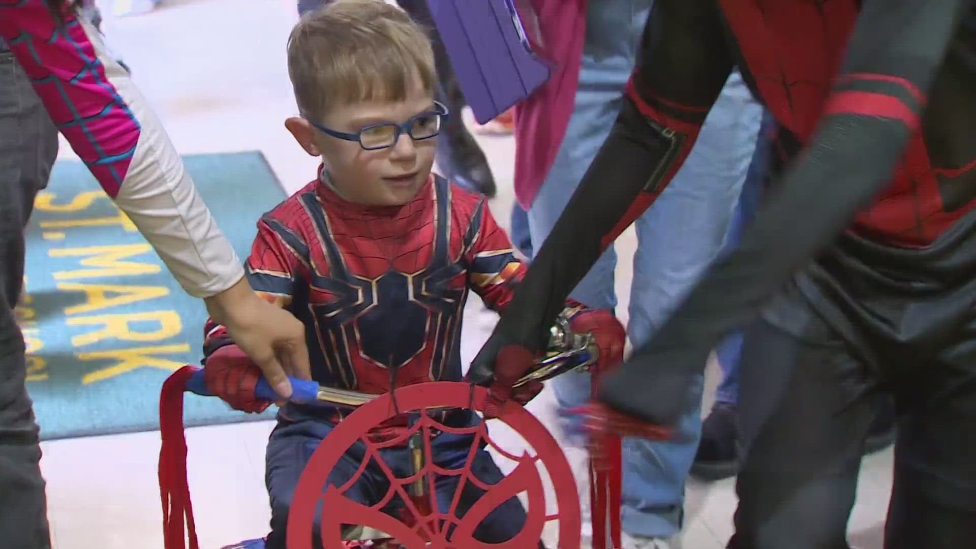 A 4-year-old boy in a Spider-Man outfit paraded through St. Mark Catholic School in Plano on Wednesday, vanquishing villains and rescuing fellow superheroes.