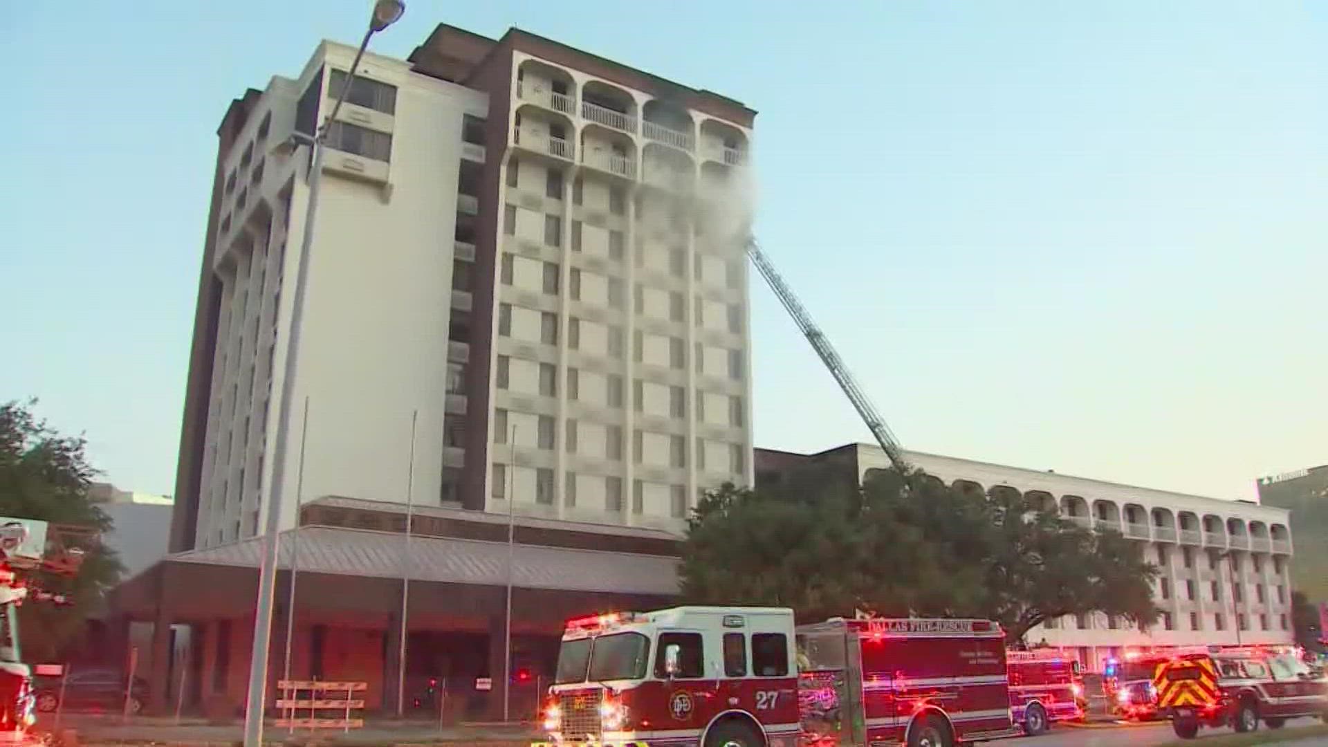 The westbound lanes of W Mockingbird Lane is shut down near Stemmons Freeway as crew work against the fire.