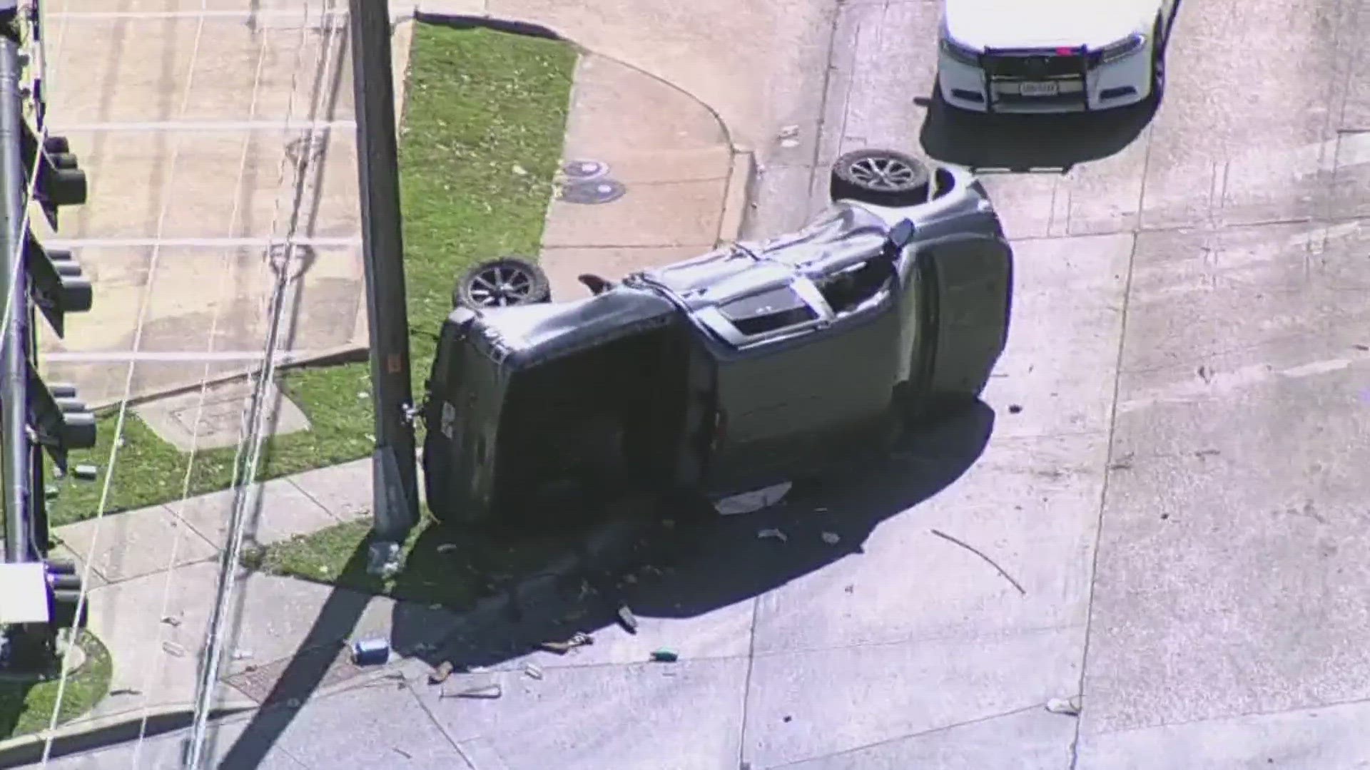 A suspect's car hit a truck, knocking it on its side against a power pole.