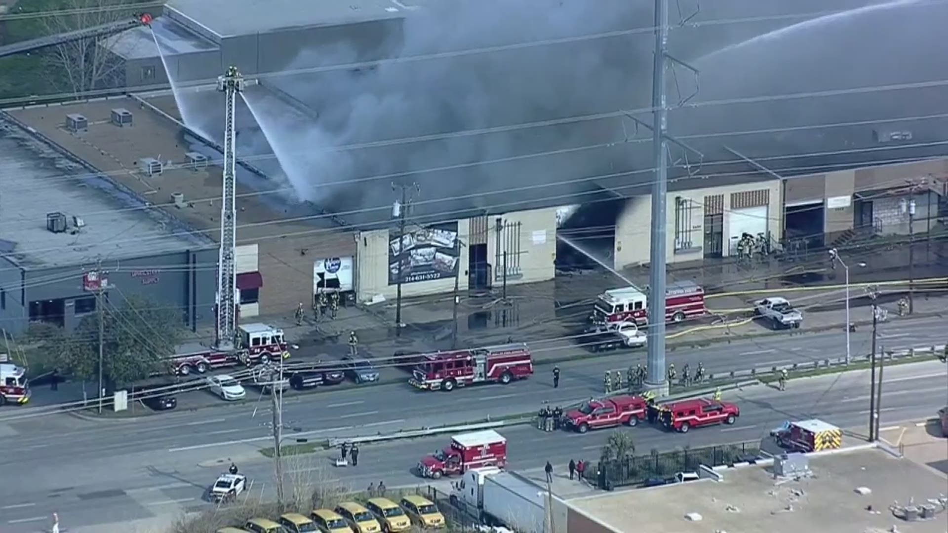 Dallas Fire-Rescue crews work to contain a fire at an upholstery warehouse near 2460 Irving Boulevard, officials say. The cause of the fire is under investigation.