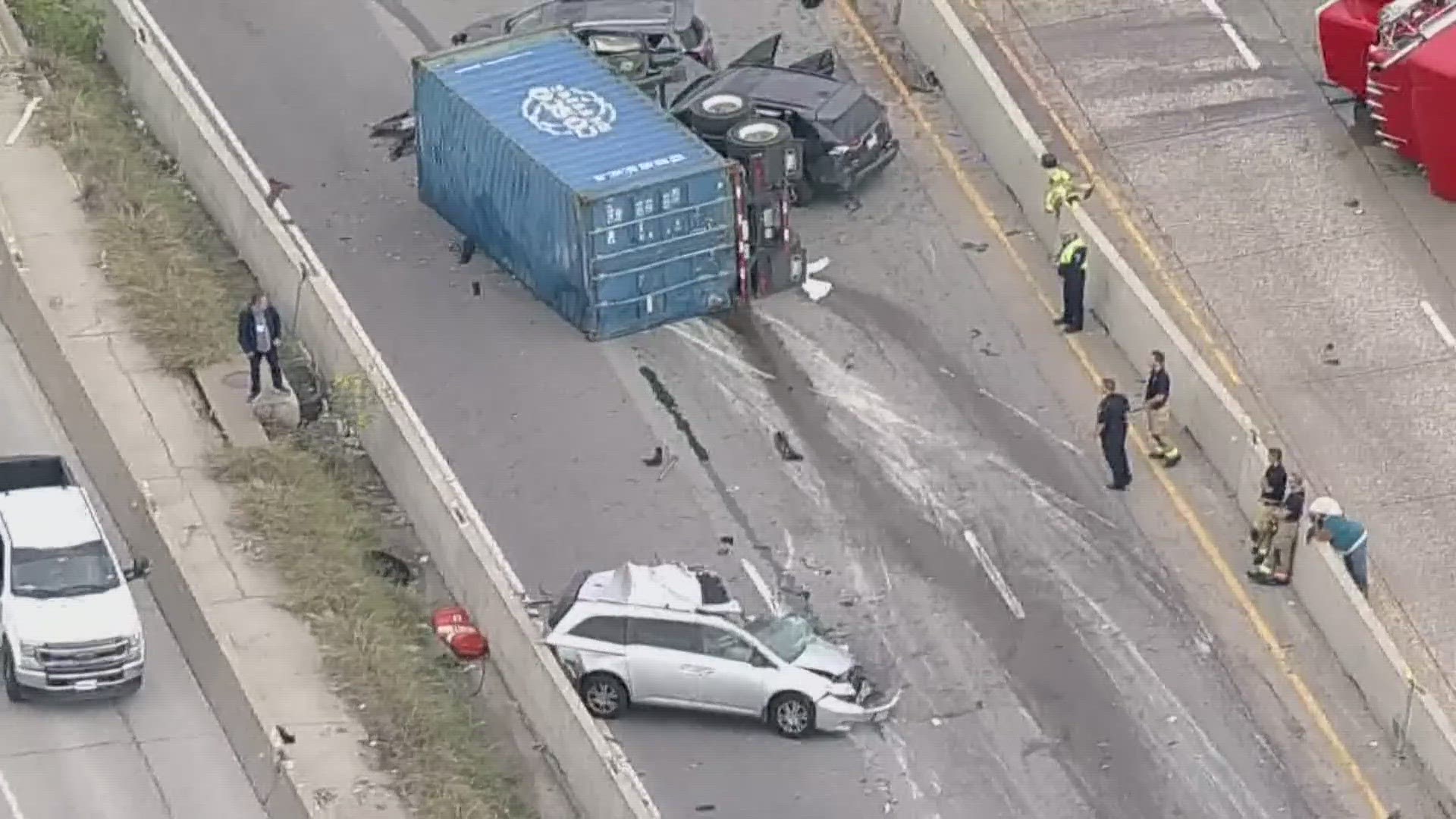 Police said the semi-truck hit a center barrier on the highway and then flipped onto its side.