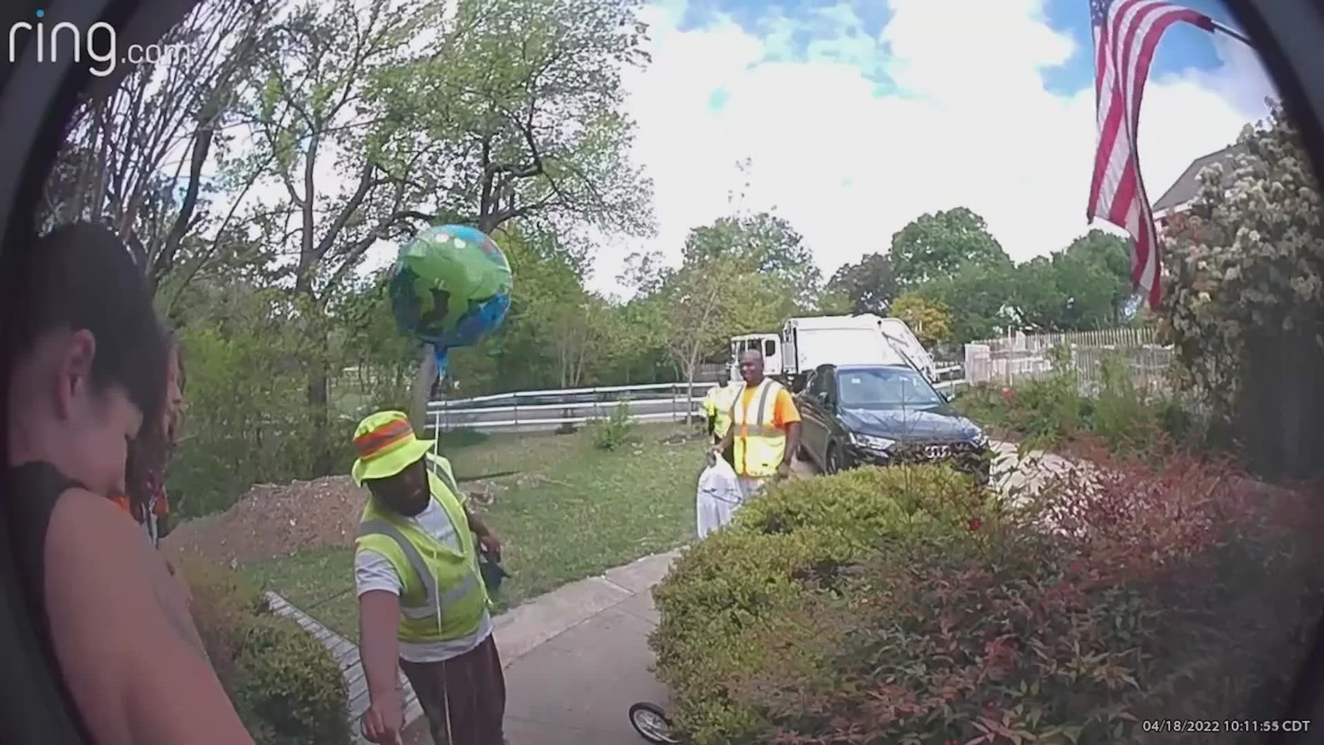 The sanitation team is seen knocking on the family’s door to surprise their little buddy with balloons and a bag of toys, after hearing the boy had a tough week.