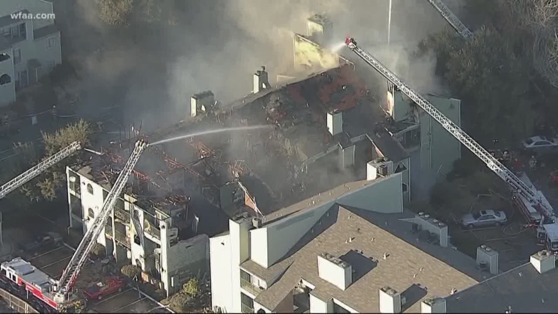 Four-alarm fire rips through condos