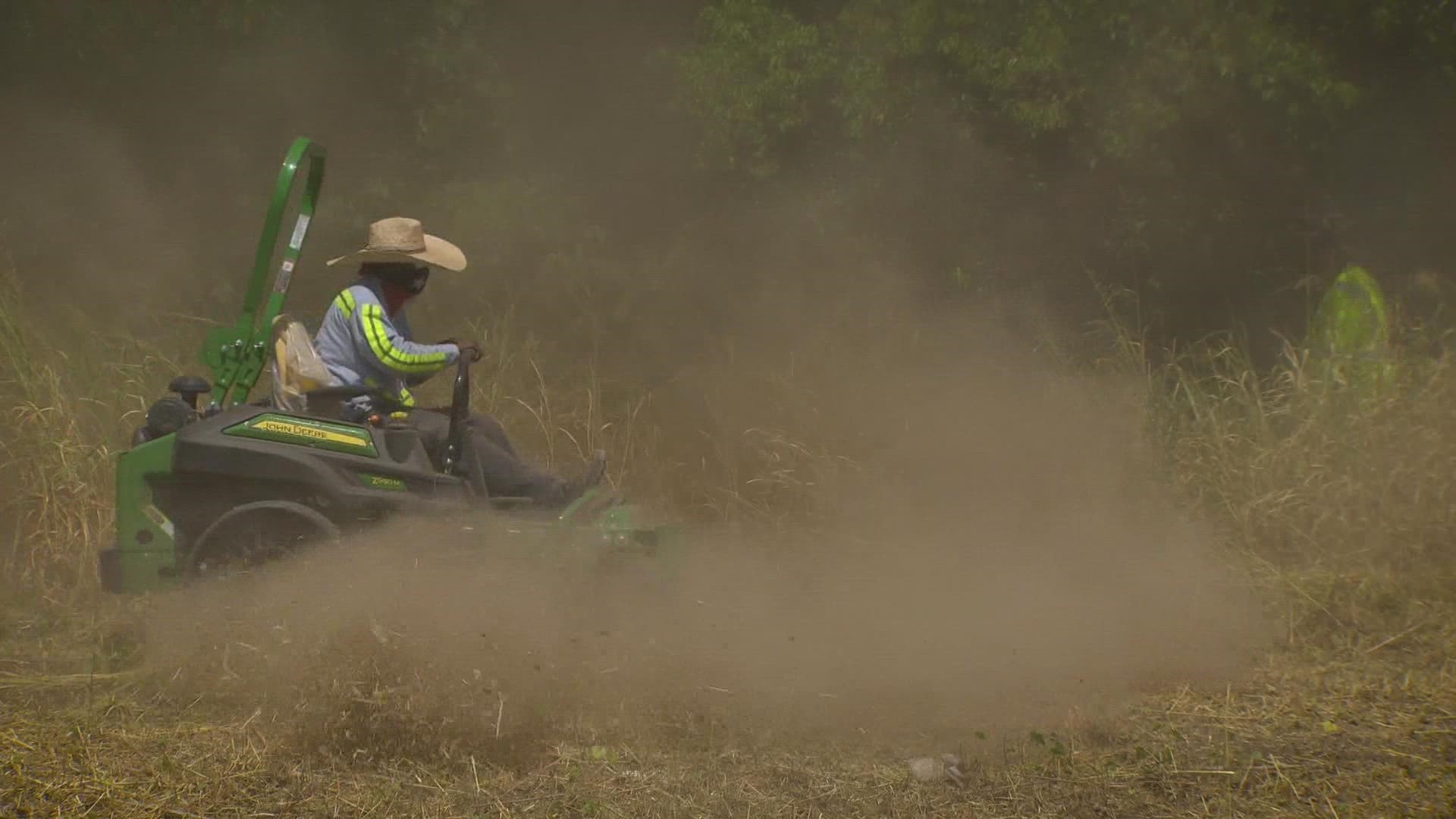 City workers mow down overgrown lots filled with weeds to lower the risk of grass fires. The city is reporting people to report any overgrown lots they see.