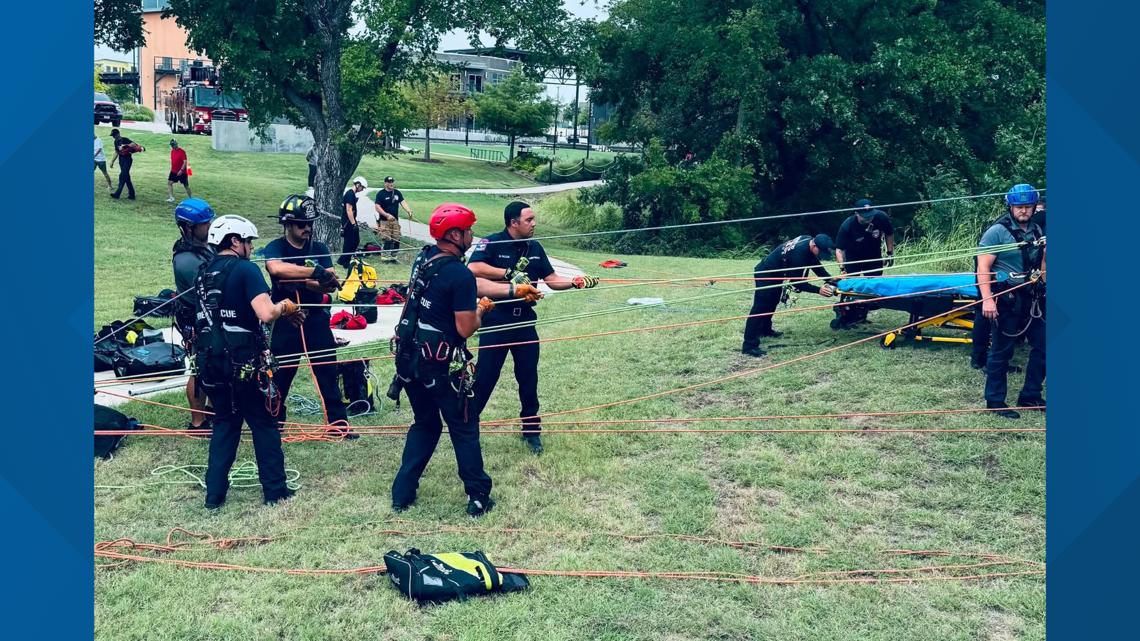 Rescue crews save injured person after 25-foot fall down riverbank in ...