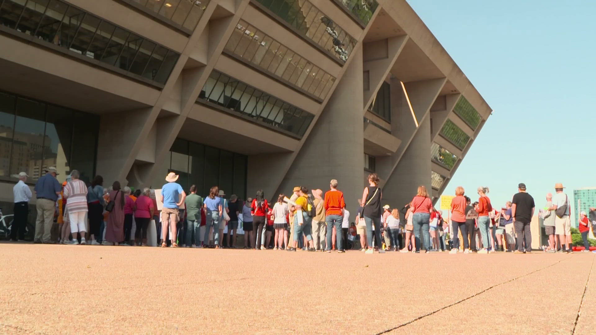About 150 rallied in front of Dallas City Hall as the nation's best-known gun rights group held its annual meeting next door